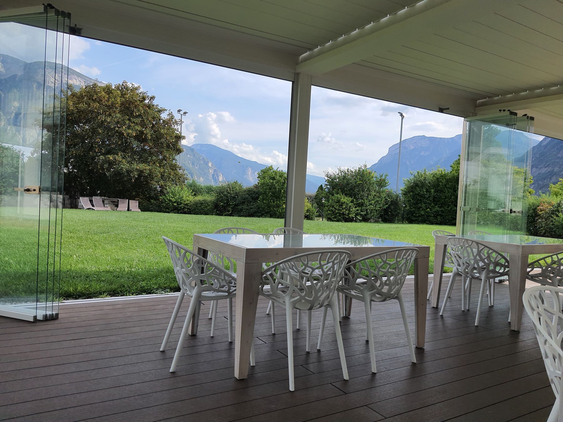 Veranda vetrata affacciata sul prato e sulle montagne